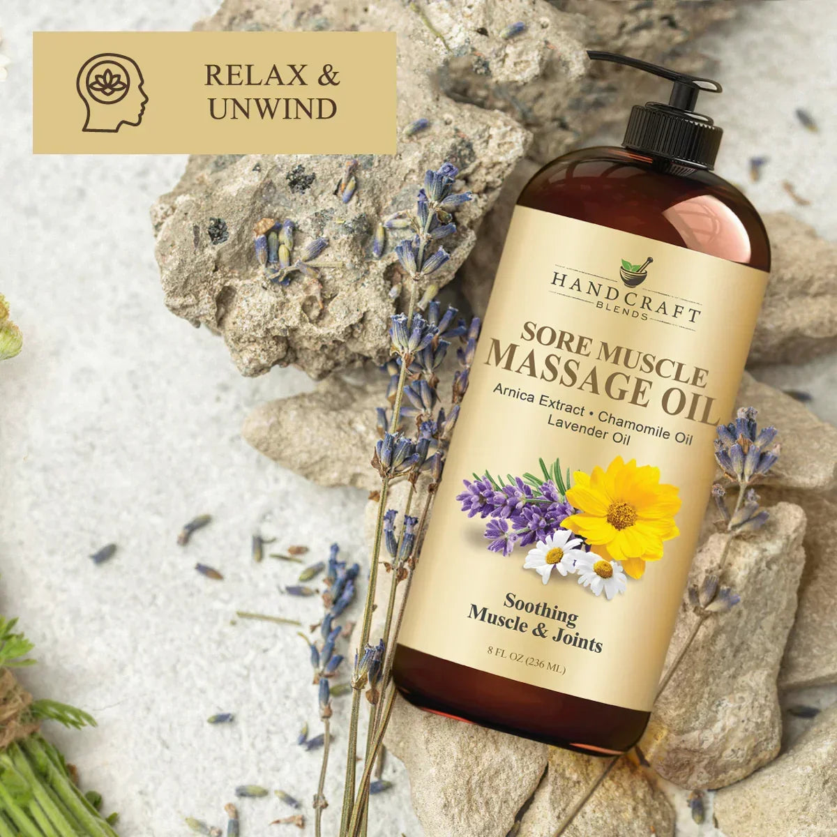 Sore muscle massage oil bottle with lavender, chamomile, and arnica flowers on a stone background.