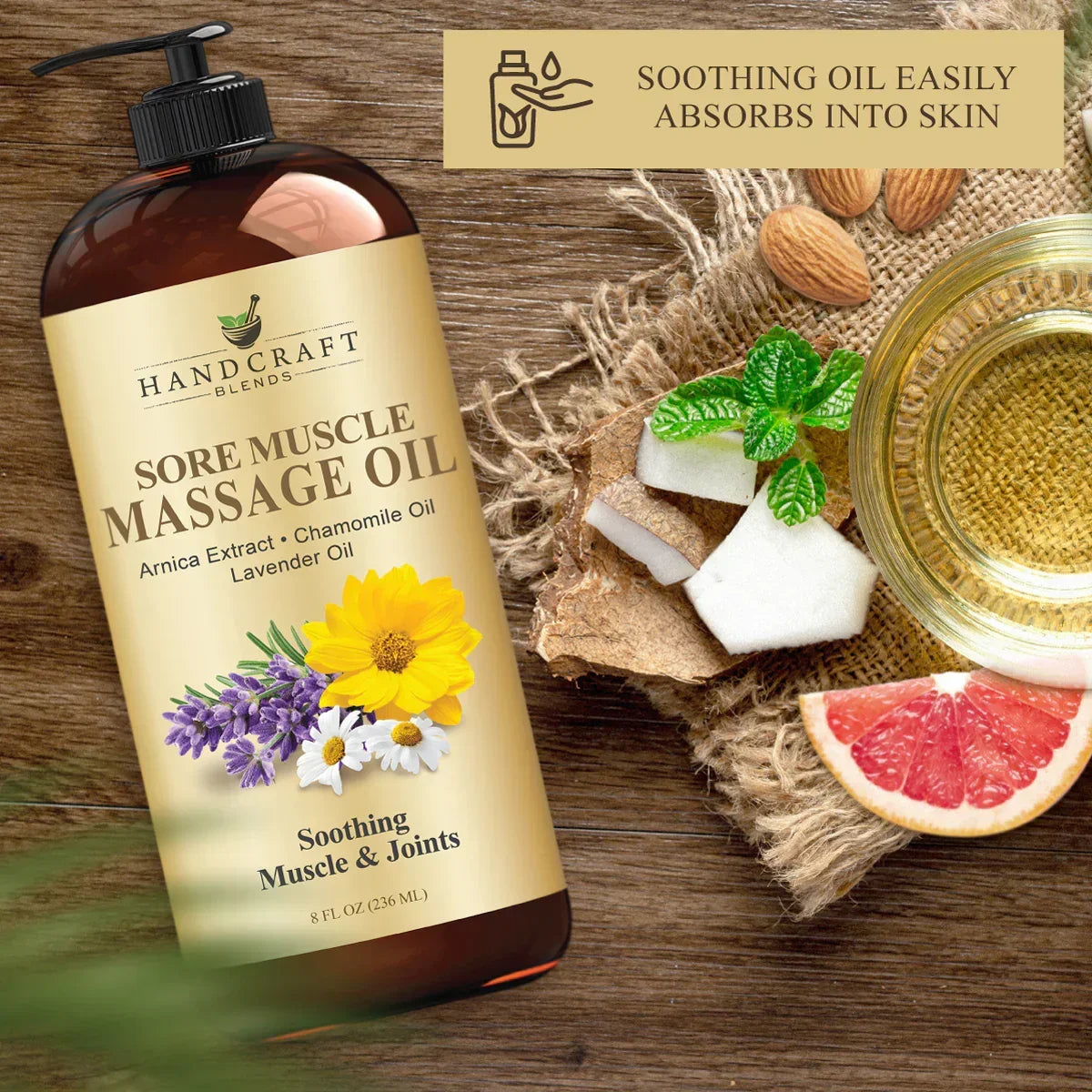 Sore muscle massage oil bottle with arnica, chamomile, lavender, oils, coconut, almonds, grapefruit, and mint on wooden surface.