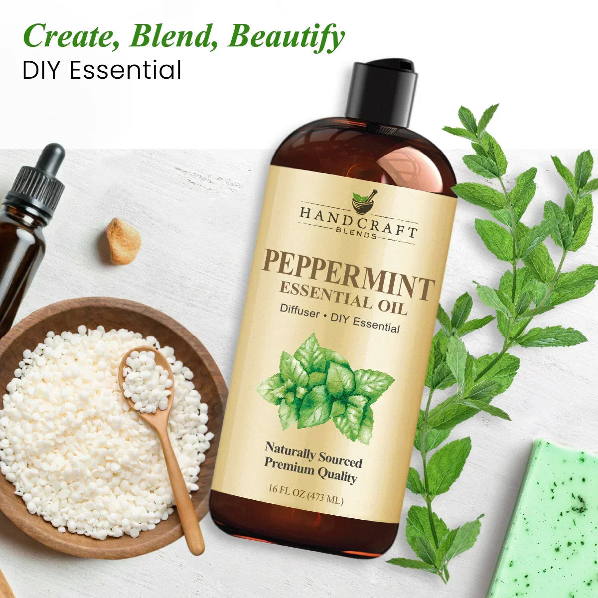 Peppermint essential oil bottle with mint leaves, beads, dropper, and soap on white background