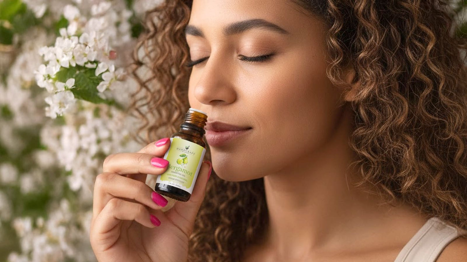 Woman enjoying bergamot essential oil aromatherapy near flowering tree