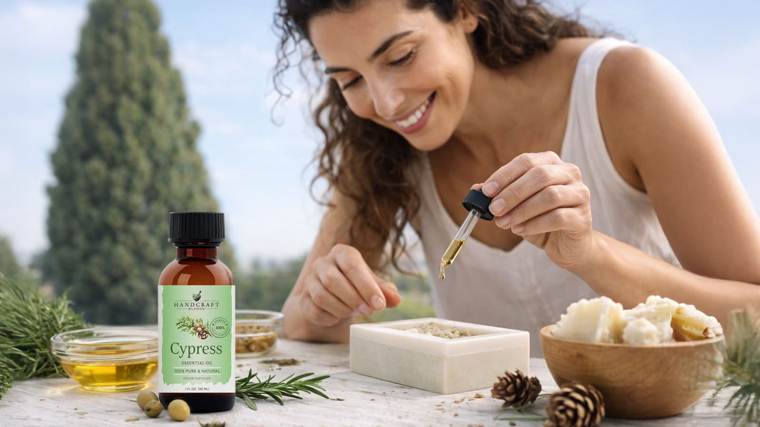 Woman using cypress essential oil with dropper, natural ingredients and pine outdoors