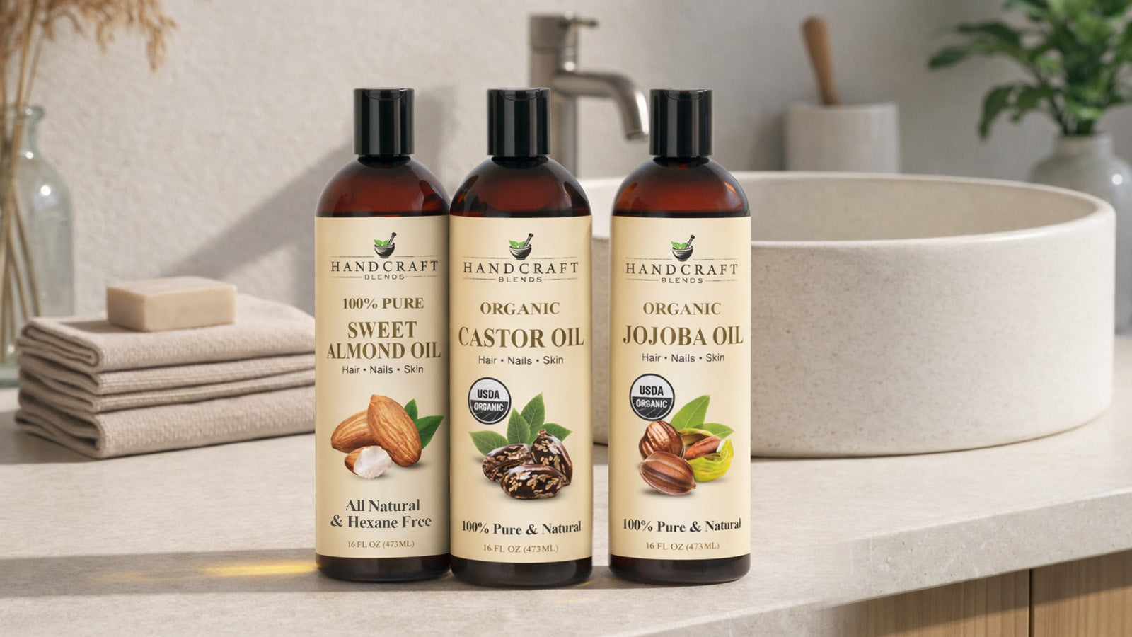Organic carrier oils for hair, nails, and skin on bathroom counter: sweet almond, castor, jojoba.