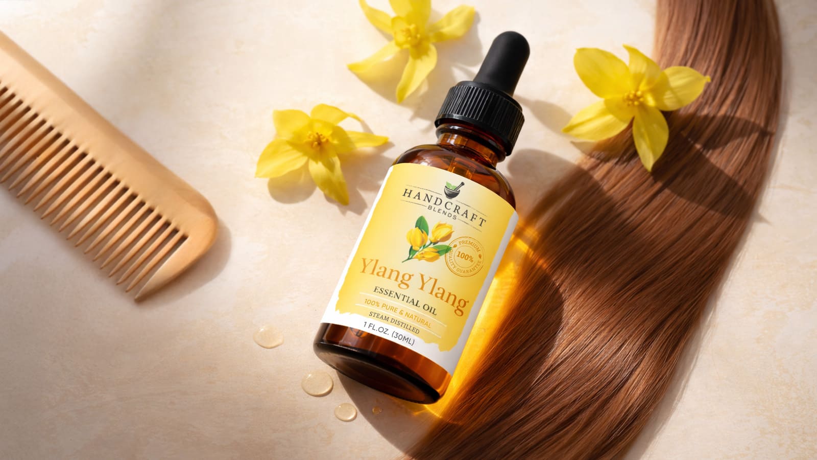 Ylang ylang essential oil bottle with yellow flowers, wooden comb, and brown hair strand
