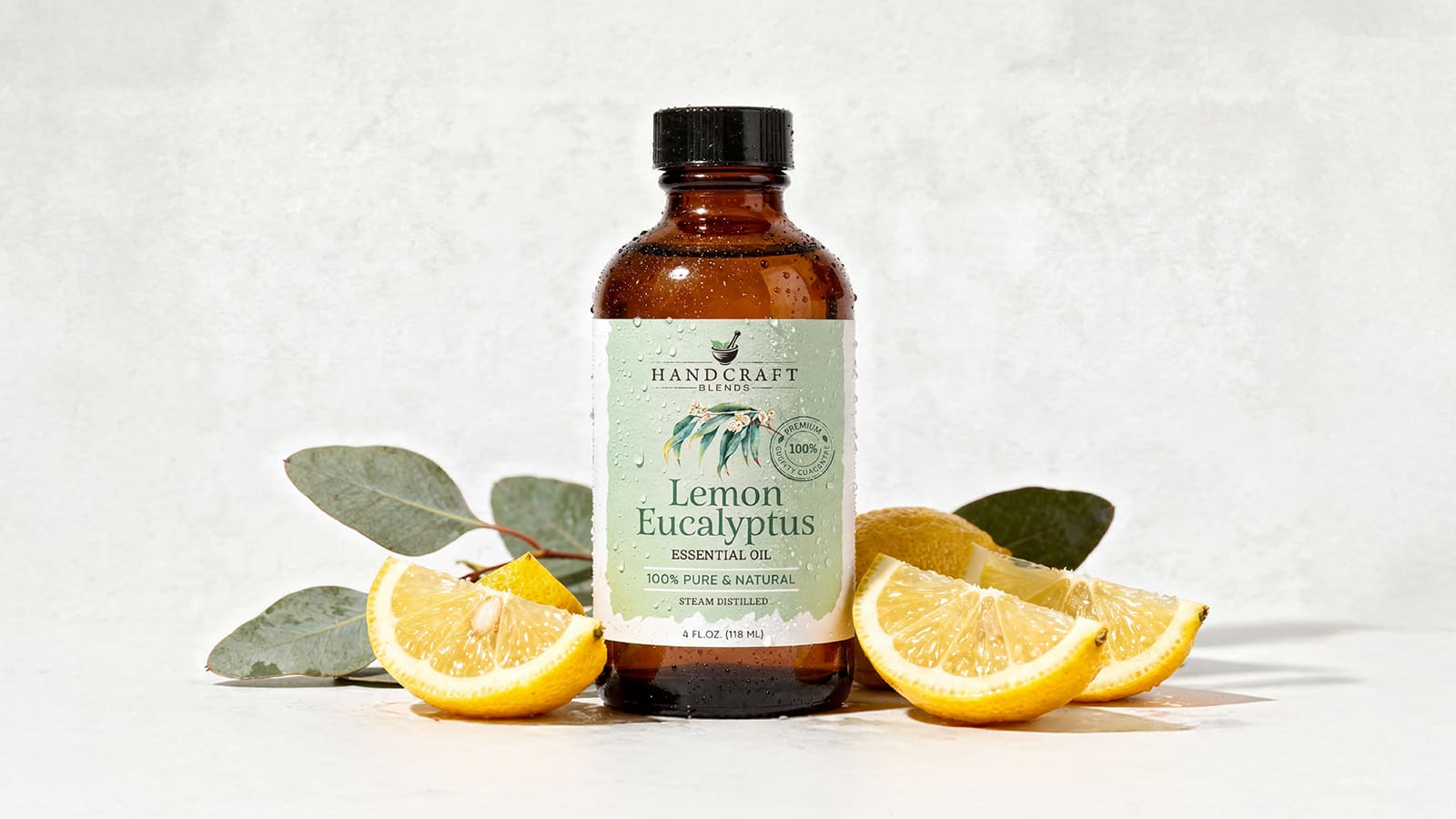 Lemon eucalyptus essential oil bottle with fresh lemon slices and eucalyptus leaves