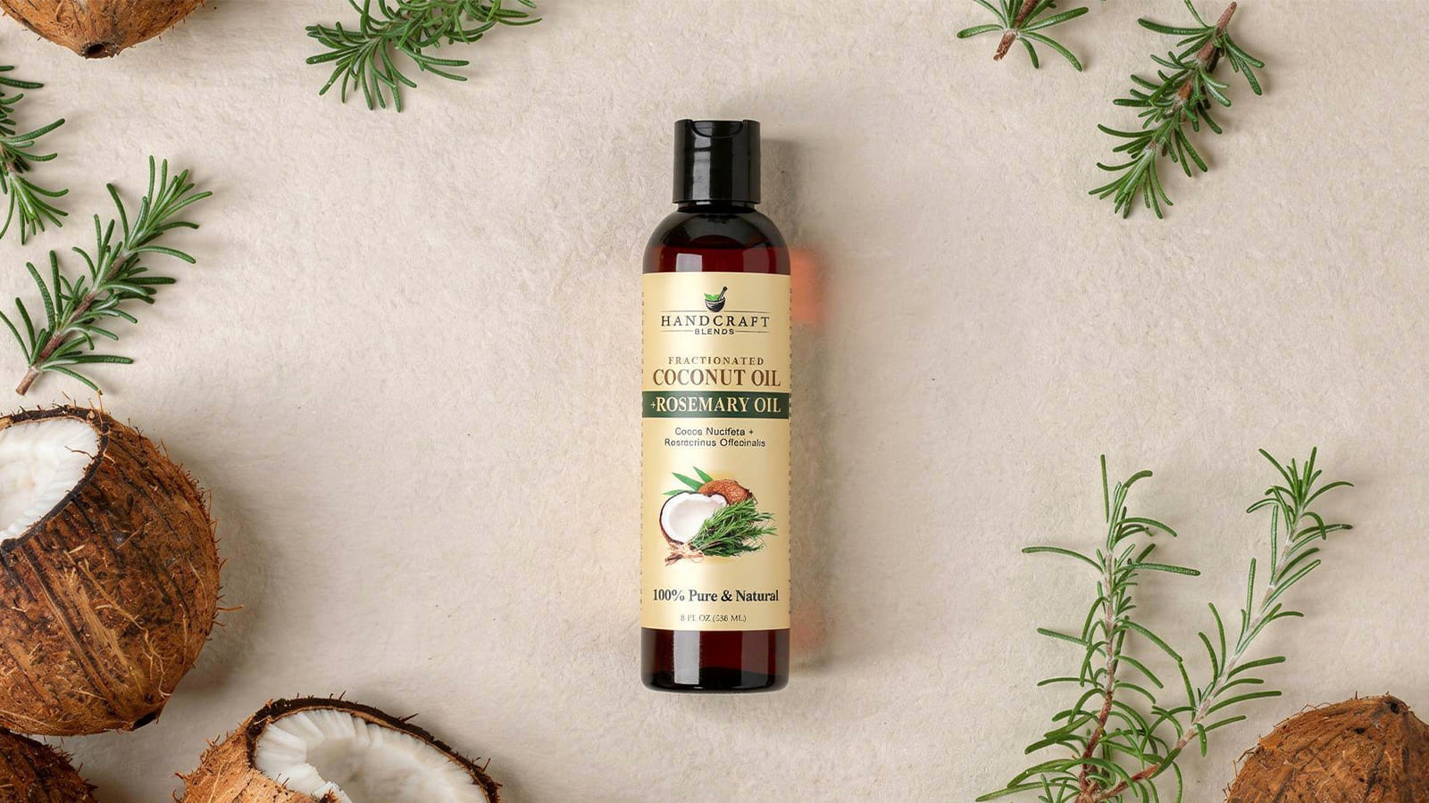 Fractionated coconut oil and rosemary oil bottle with coconut halves and rosemary sprigs