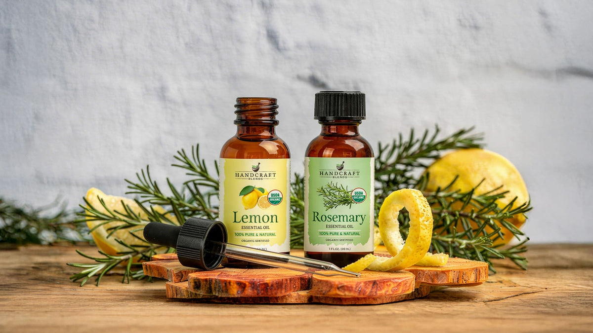 Grapefruit and rosemary essential oil bottles beside fresh citrus slices and rosemary sprigs
