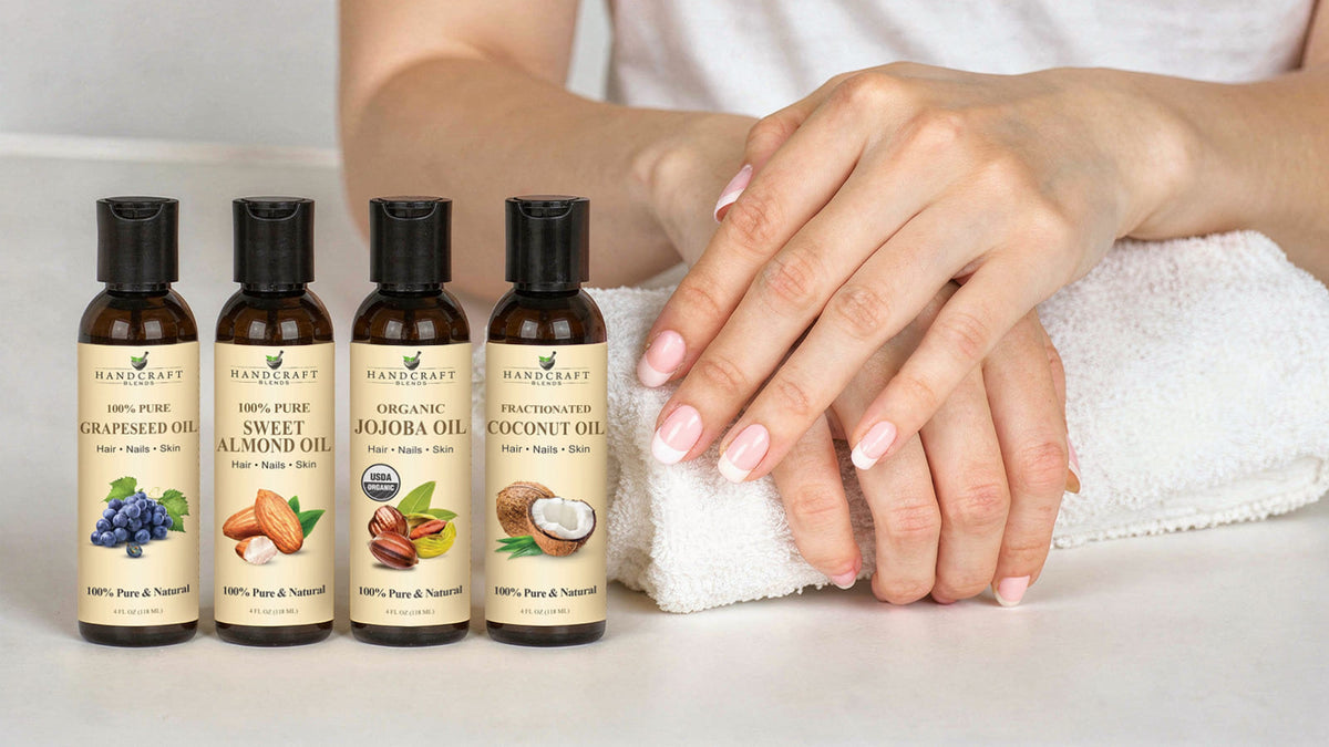 Jojoba and sweet almond carrier oil bottles beside a small brush-cap cuticle oil bottle