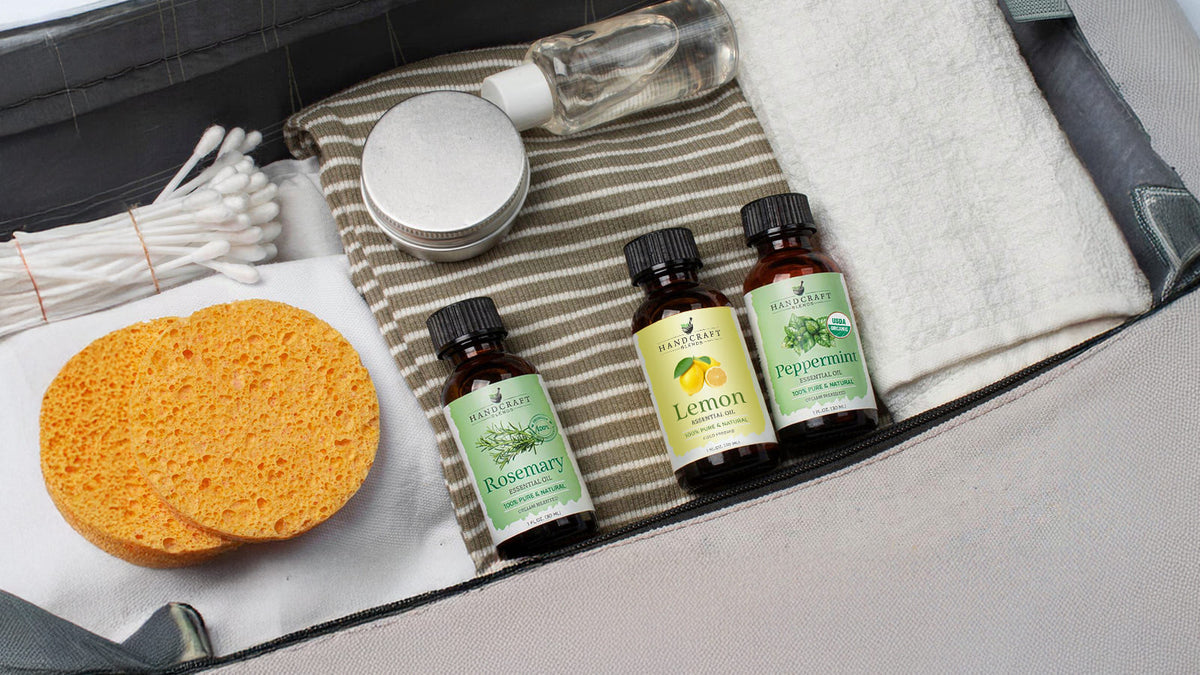 Small bottles of lavender and sweet orange essential oil packed in a travel pouch