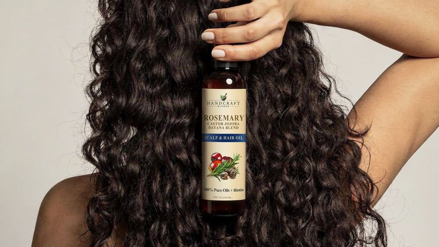 Organic castor oil bottle for hair, nails, and skin on a bathroom counter with towels.